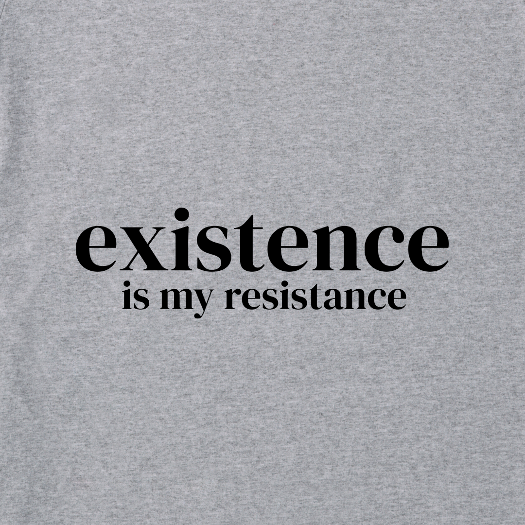 Image of grey t-shirt material with the words 'Existence is My Resistance' in black in the middle of the image.