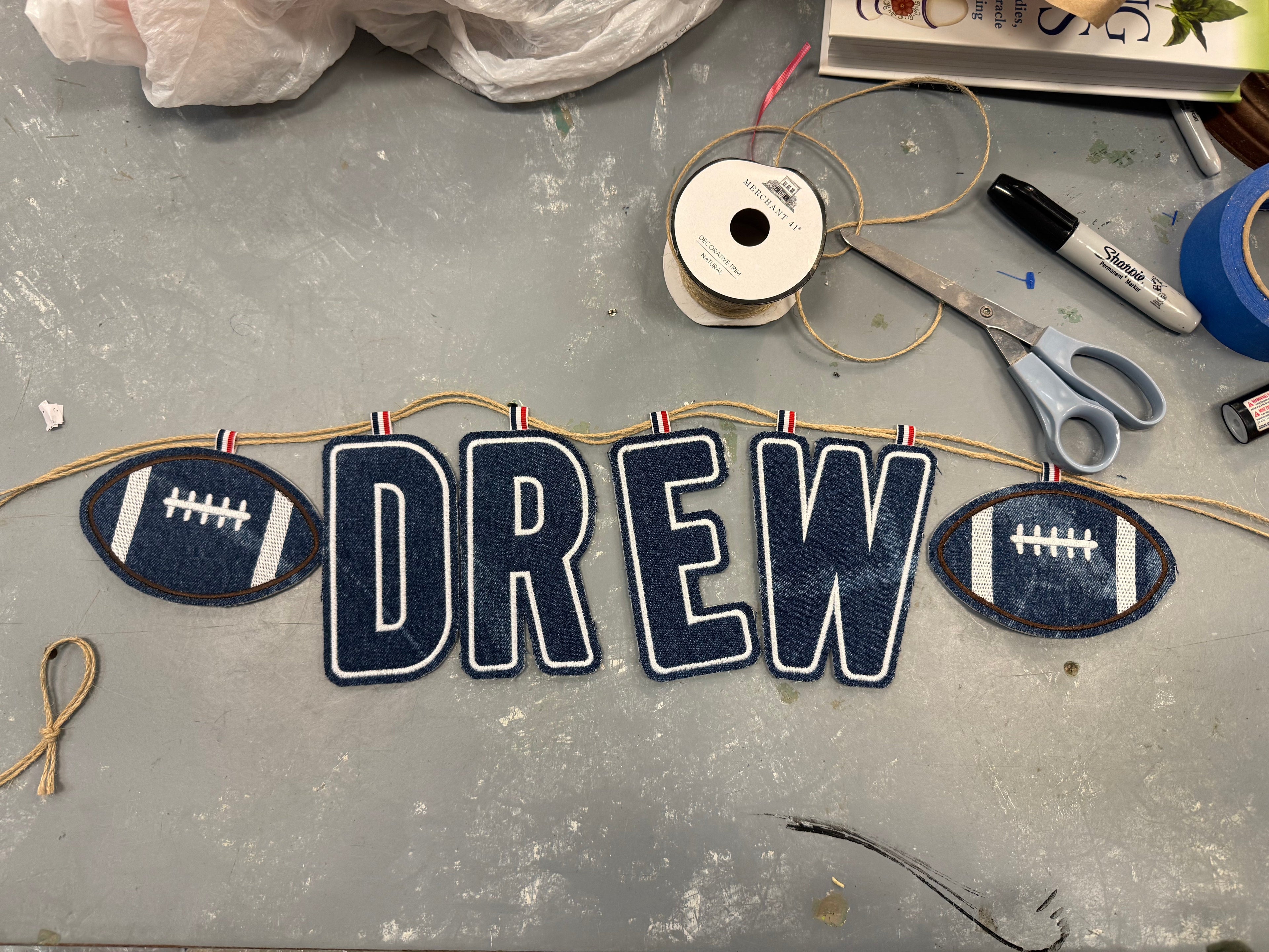 Personalized name sign with football designs on a gray surface